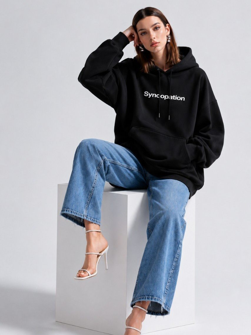 Wordmark hoodie photographed seated in the studio